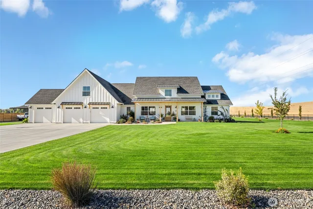 a view of a big house with a big yard and large trees
