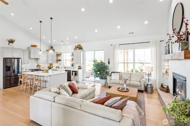 a living room with fireplace furniture and a large window