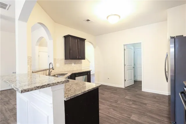 a kitchen with granite countertop a sink and a refrigerator