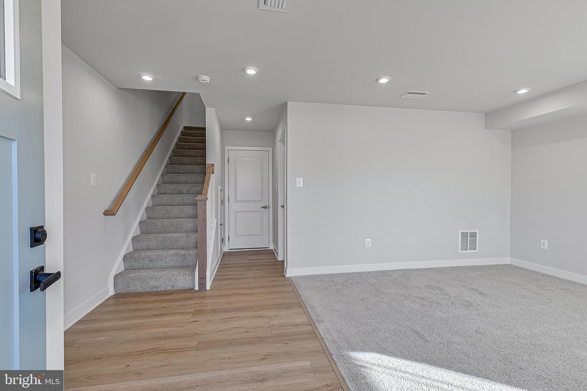 1 B Oasis Avenue Ranson, WV 25438 - Photo 2 of 39 an empty room with wooden floor and staircase