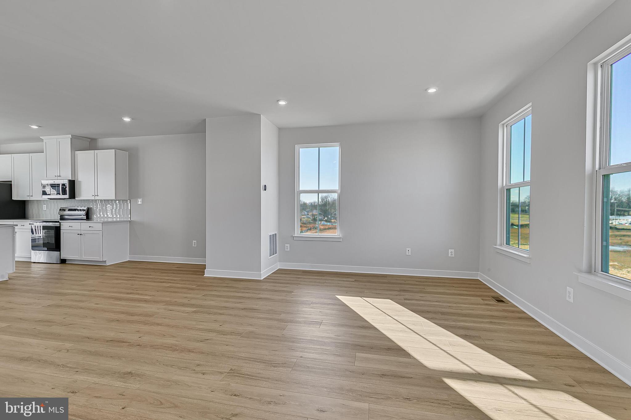 1 B Oasis Avenue Ranson, WV 25438 - Photo 24 of 39 a view of empty room with wooden floor and kitchen