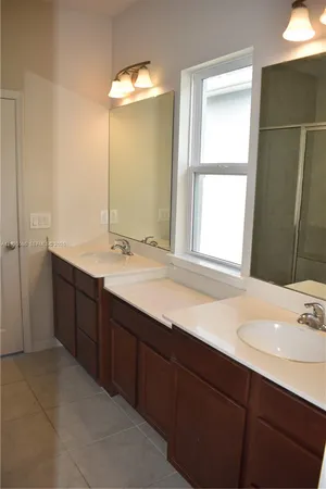 a bathroom with a double vanity sink and a window