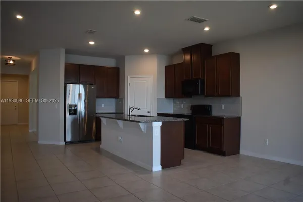 a kitchen with stainless steel appliances granite countertop a refrigerator and a stove top oven