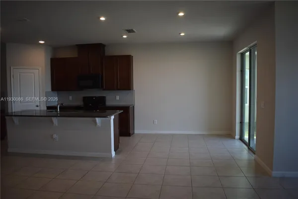 a kitchen with kitchen island granite countertop a stove top oven a sink and a microwave