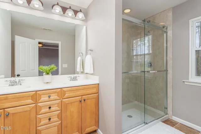 a bathroom with a shower sink vanity and mirror