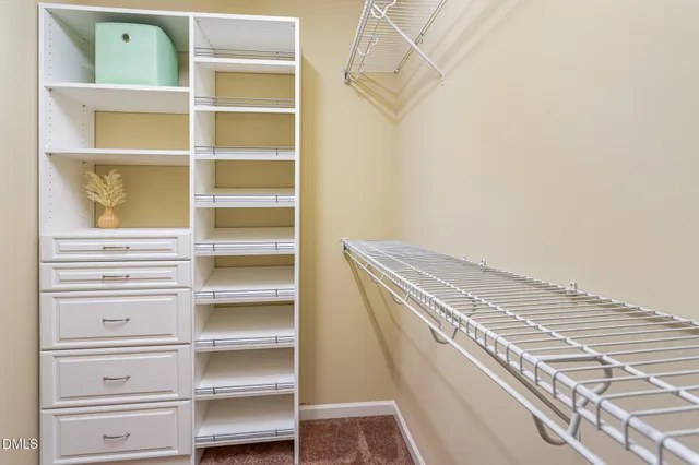 a view of walk in closet with empty racks