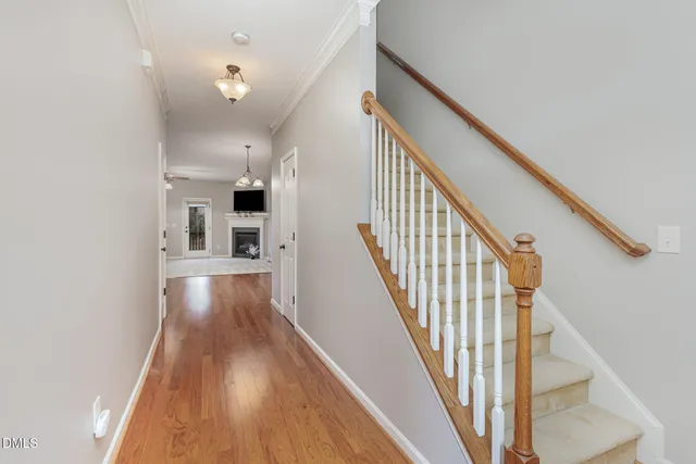 a view of a hallway with wooden floor and staircase