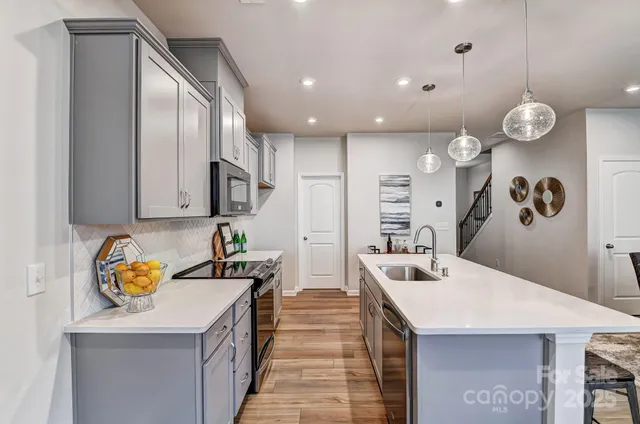 a kitchen with a sink a stove and cabinets