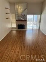 en empty room with wooden floor fireplace and windows