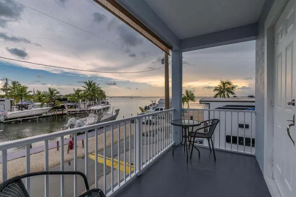 a view of a balcony with table and chairs and wooden floor