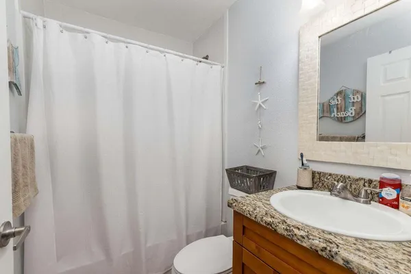 a bathroom with a granite countertop sink and a mirror