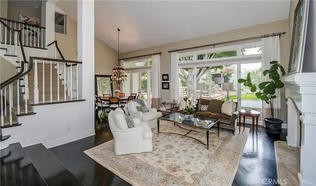 a living room with furniture large window and wooden floor