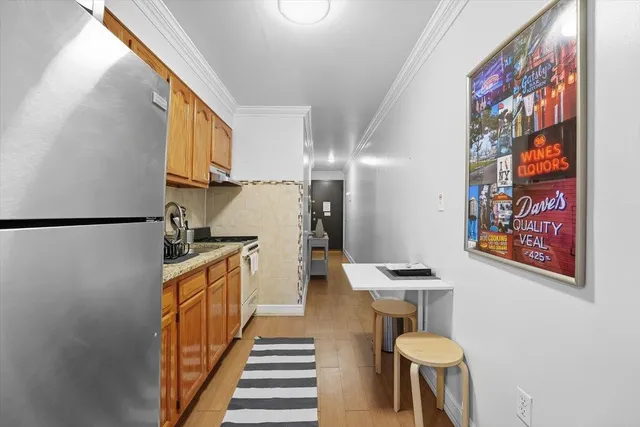 a kitchen with stainless steel appliances kitchen island granite countertop a sink and a refrigerator