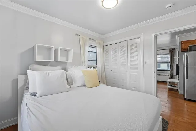 a bedroom with a bed and a view of kitchen