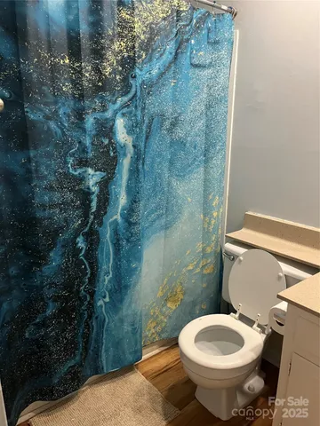 a bathroom with a toilet and a shower