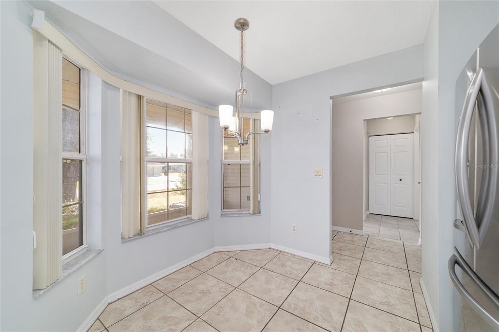 6241 Southwest 84th Place Ocala, FL 34476 - Photo 14 of 33 a view of an empty room with window and chandelier fan