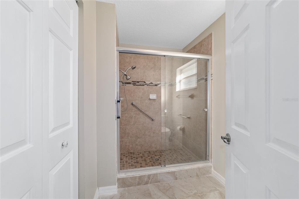 6241 Southwest 84th Place Ocala, FL 34476 - Photo 19 of 33 a bathroom with a glass shower door