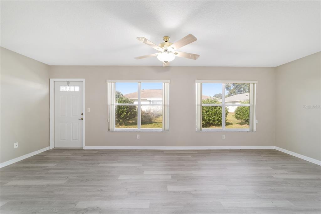 6241 Southwest 84th Place Ocala, FL 34476 - Photo 9 of 33 an empty room with wooden floor and windows