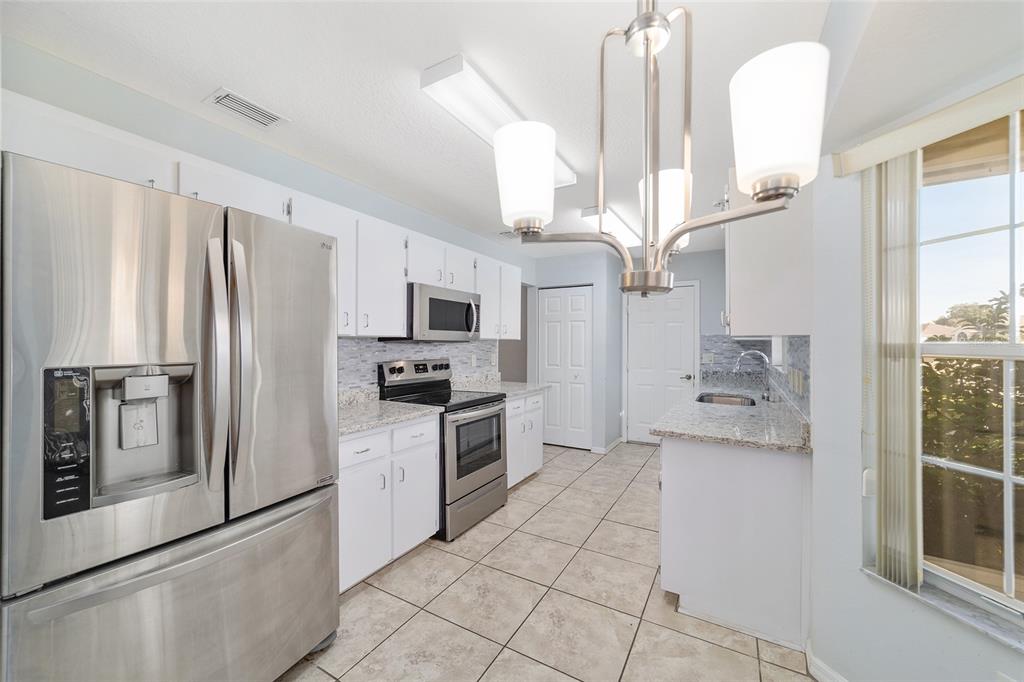 6241 Southwest 84th Place Ocala, FL 34476 - Photo 10 of 33 a kitchen with stainless steel appliances a refrigerator sink and microwave