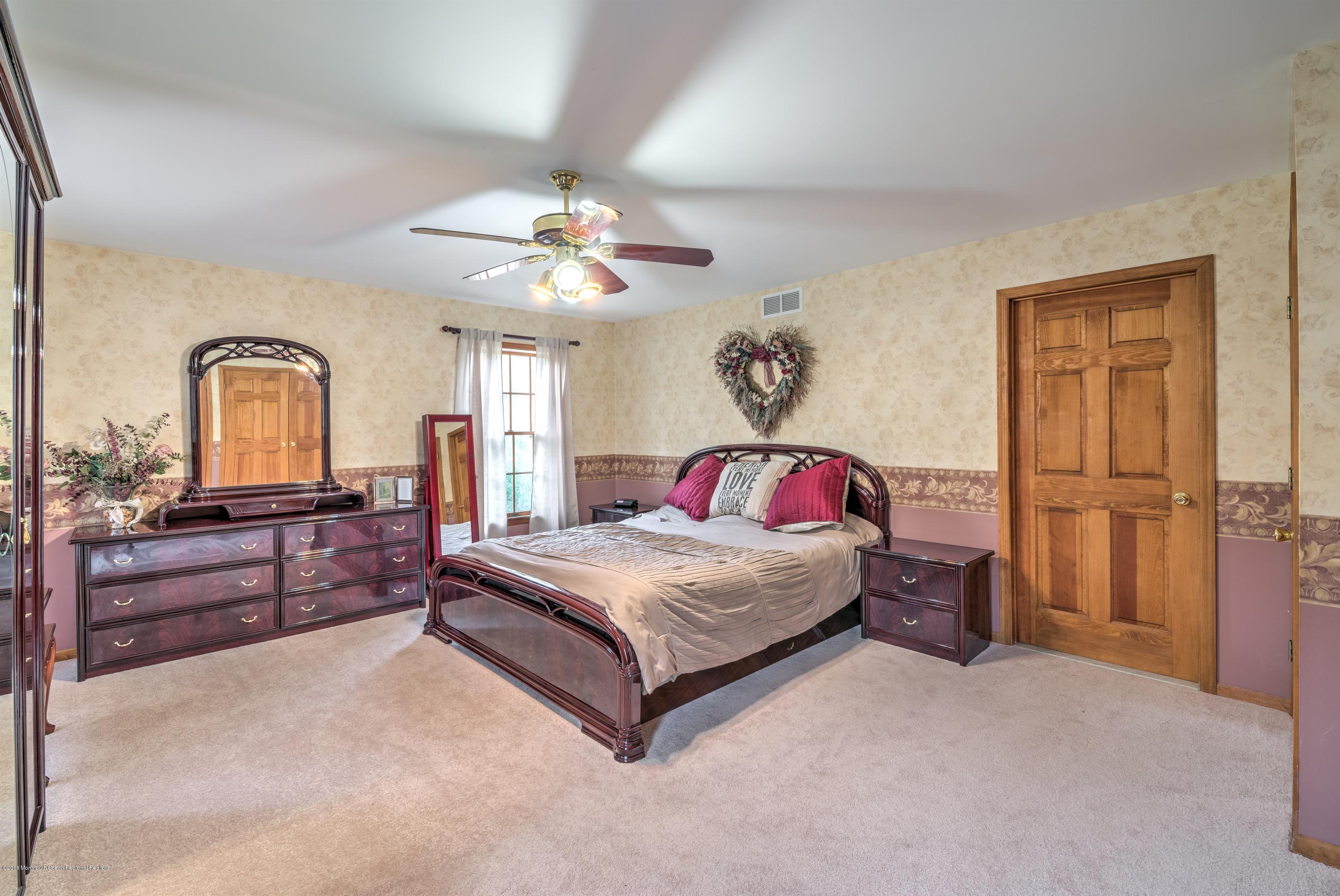 20 Hornerstown Road Cream Ridge, NJ 08514 - Photo 15 of 28 a bedroom with a large bed and a chandelier
