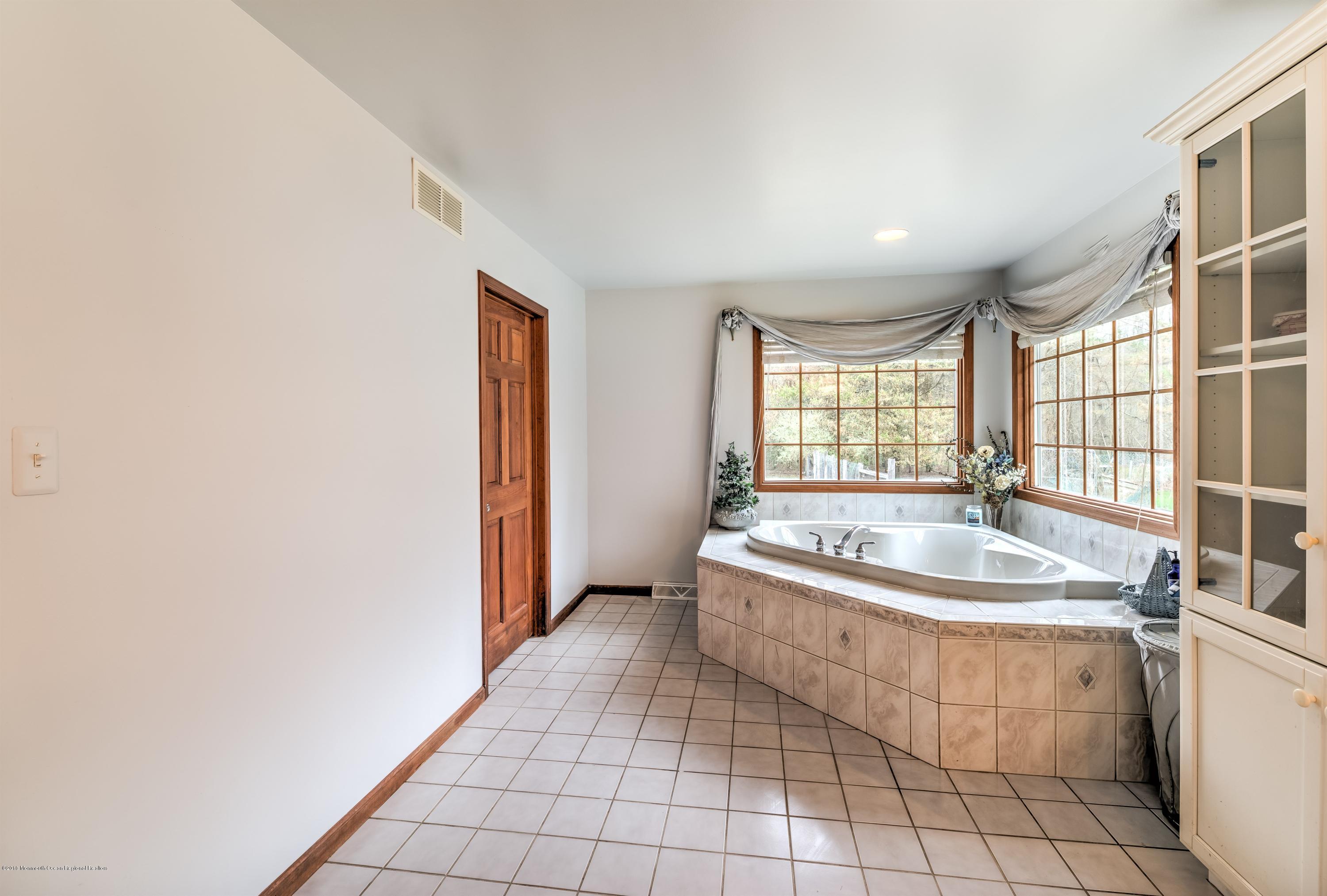 20 Hornerstown Road Cream Ridge, NJ 08514 - Photo 18 of 28 a bathroom with a granite countertop sink a mirror and a bathtub