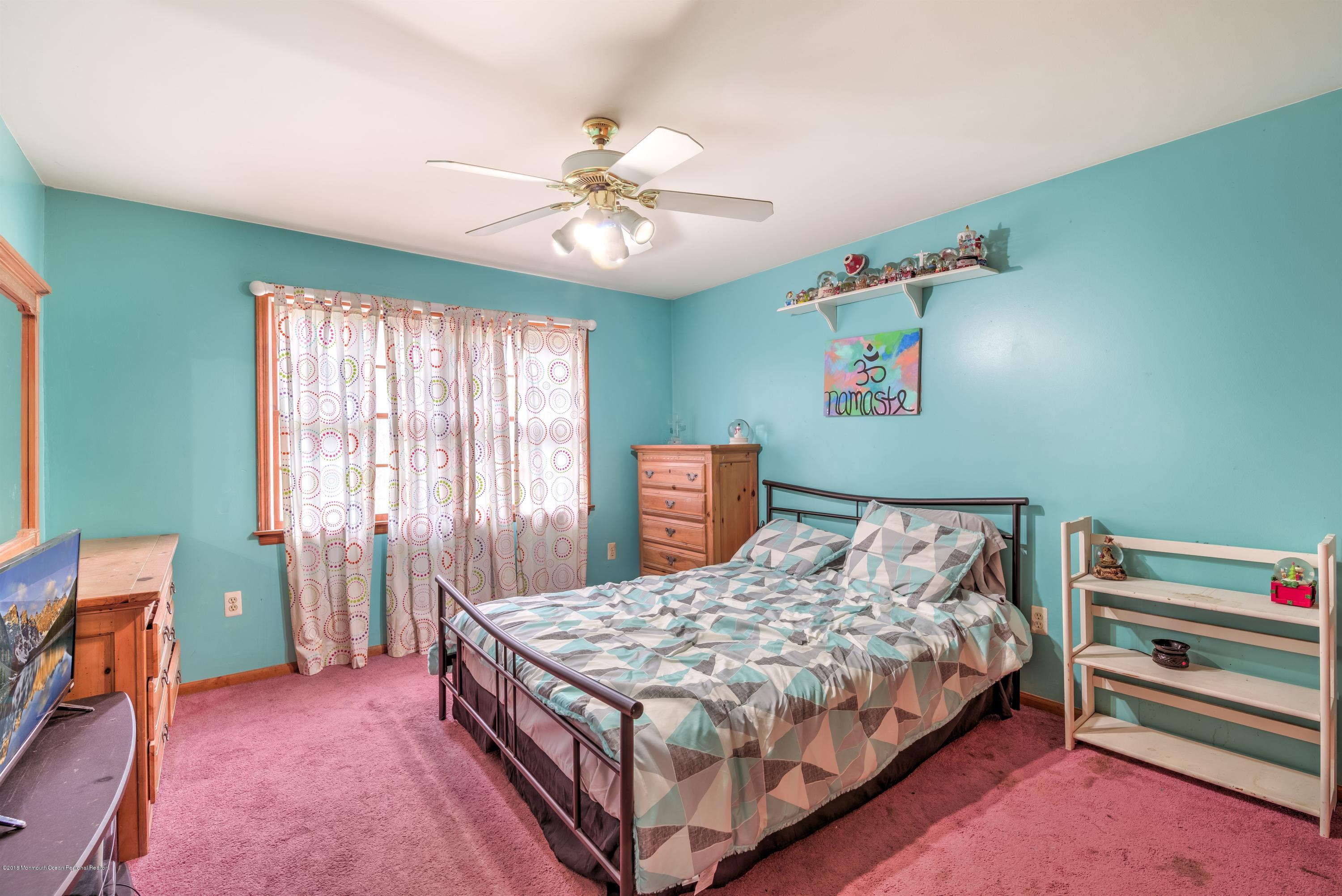 20 Hornerstown Road Cream Ridge, NJ 08514 - Photo 22 of 28 a bedroom with a bed and a chandelier