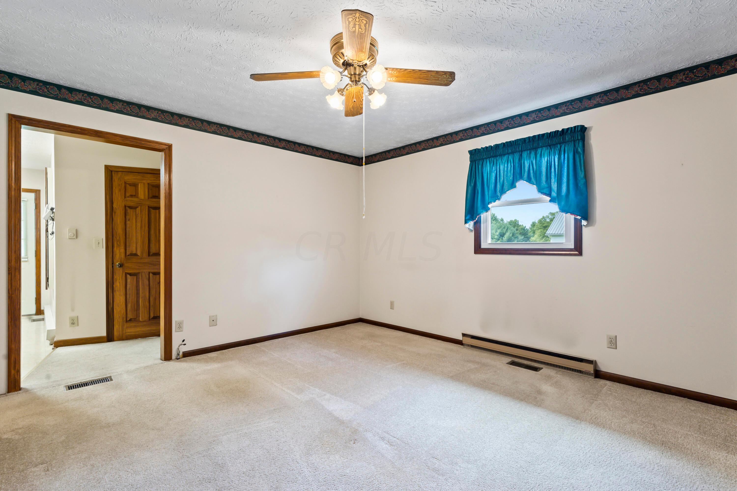 5764 Cheshire Road Galena, OH 43021 - Photo 12 of 59 • Light sand carpet
• Tan painted walls with border
• Lighted ceiling fan
• Closet with bi-fold doors