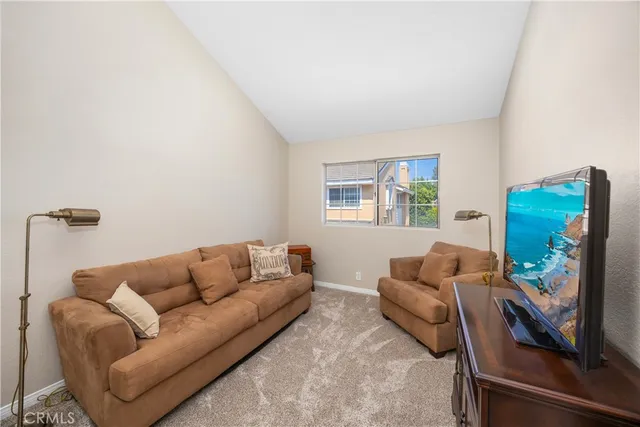 a living room with furniture a flat screen tv and a window