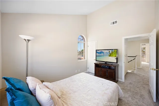 a bedroom with a bed and a tv on the dresser