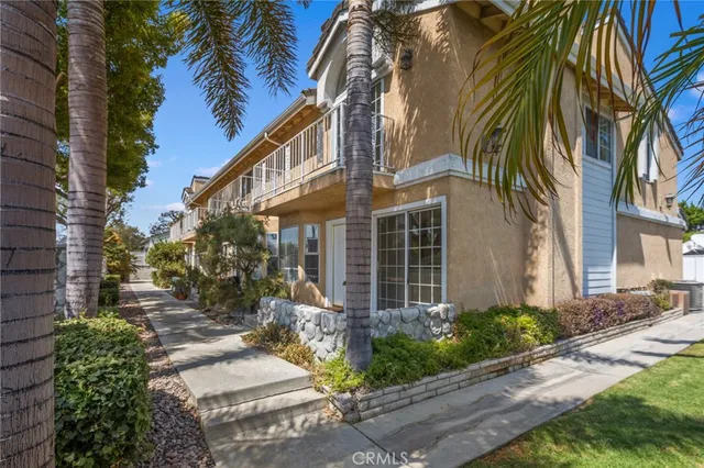 a view of a house with a yard and coconut trees
