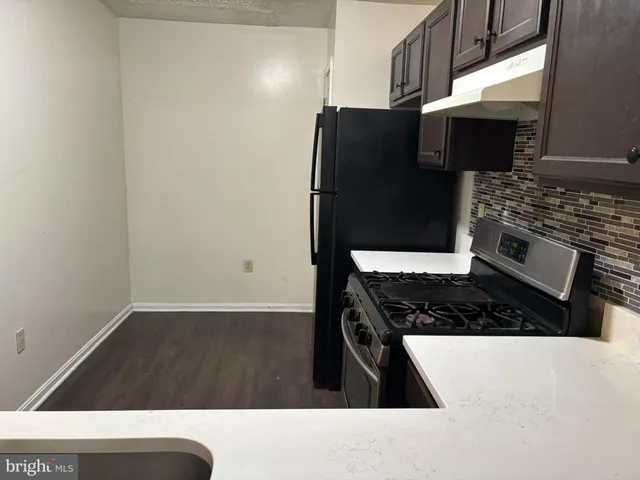 a kitchen with granite countertop a stove and a refrigerator