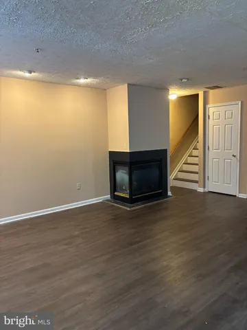 a view of empty room with wooden floor and fireplace