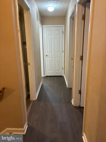 a view of a hallway with wooden floor and closet