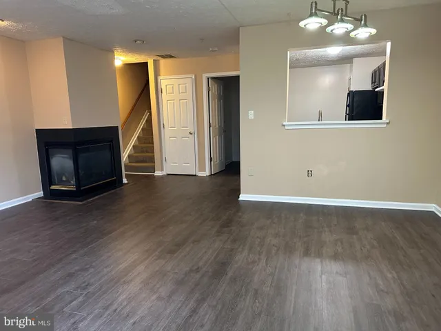 a view of a livingroom with wooden floor and staircase