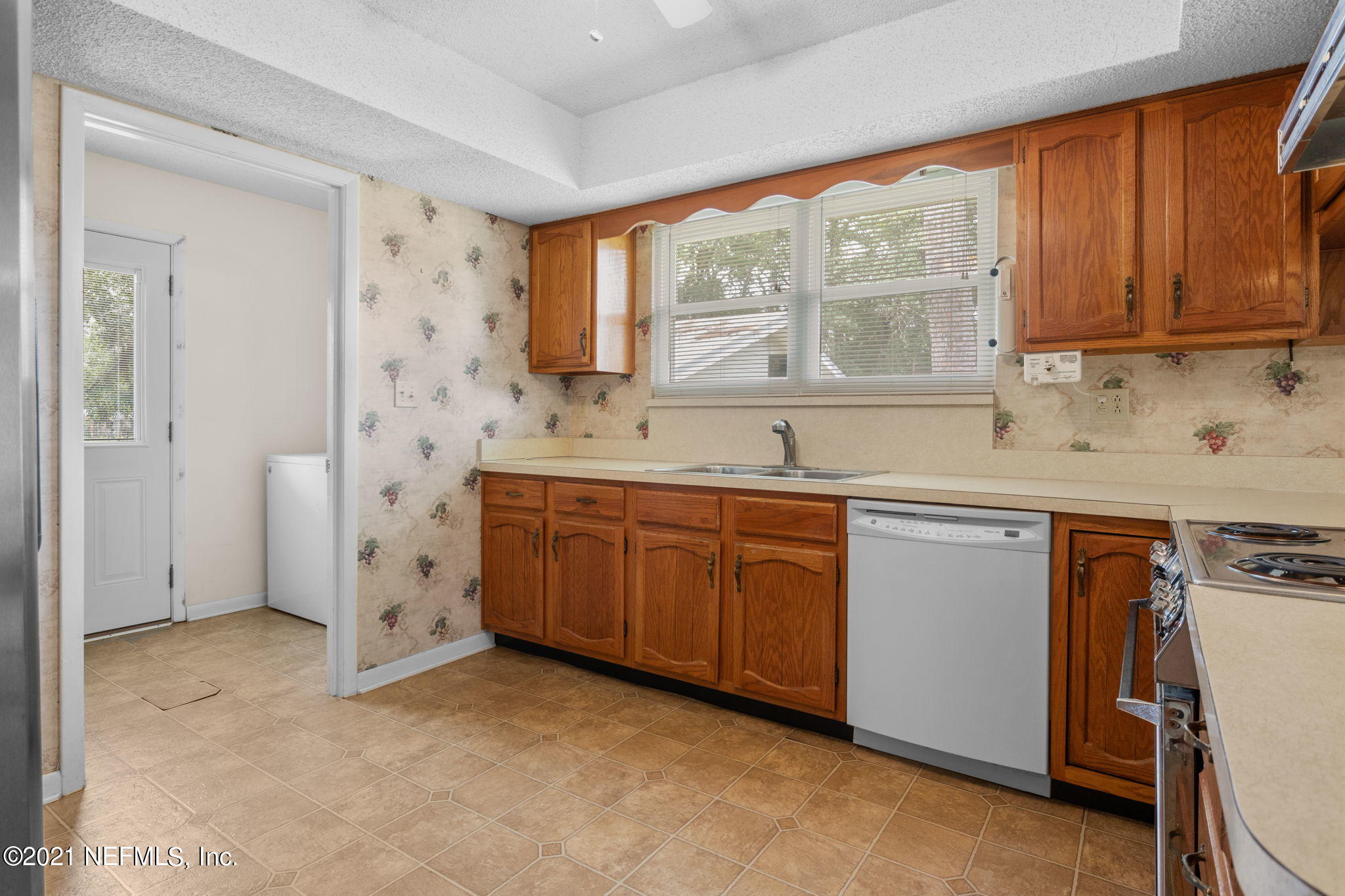 4730 Ricker Road Jacksonville, FL 32210 - Photo 11 of 30 a kitchen with granite countertop a sink window and cabinets