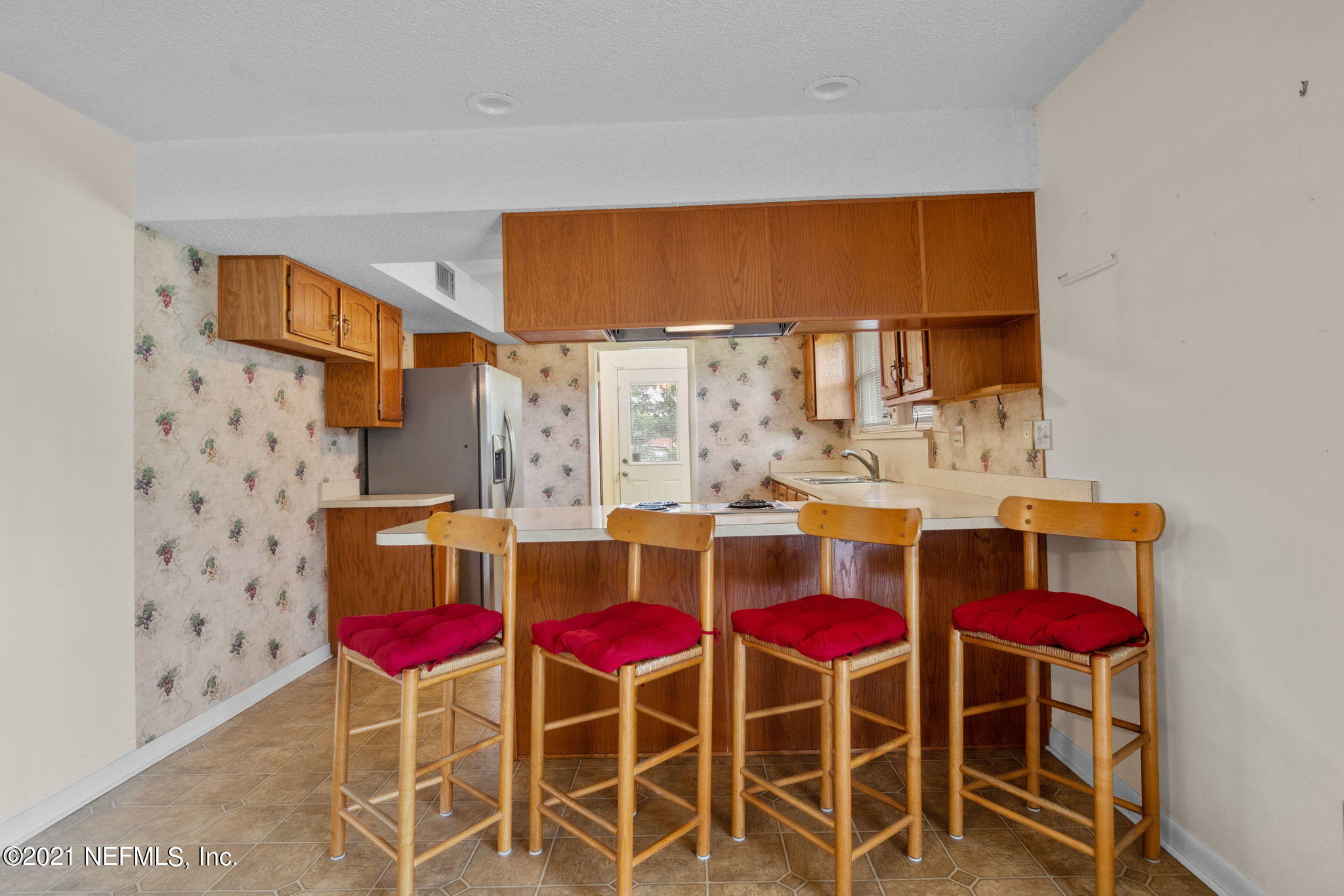 4730 Ricker Road Jacksonville, FL 32210 - Photo 13 of 30 a view of a dining room with chairs a rug and wooden floor
