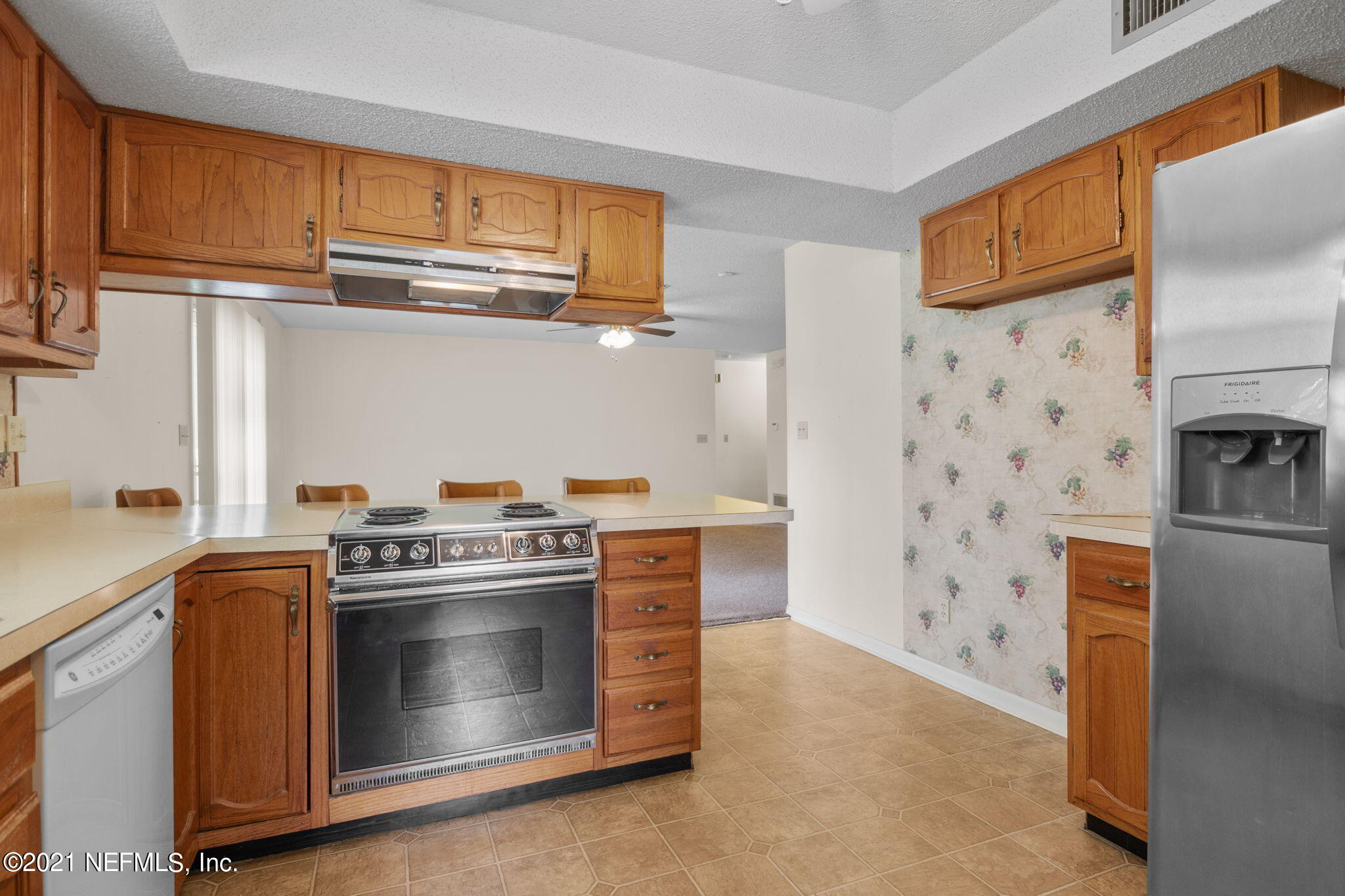 4730 Ricker Road Jacksonville, FL 32210 - Photo 9 of 30 a kitchen with stainless steel appliances granite countertop a stove a sink and a refrigerator