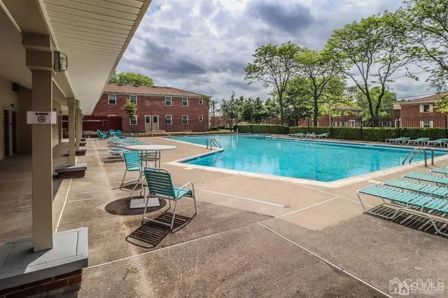 a view of a swimming pool and lounge chairs in patio