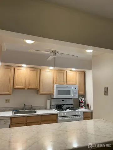 a kitchen with stainless steel appliances a sink a stove and a microwave