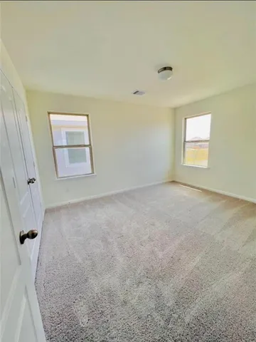 an empty room with a cabinet and a window