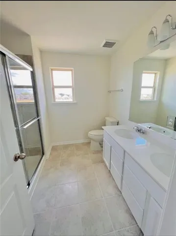 a bathroom with a double vanity sink a toilet and a mirror