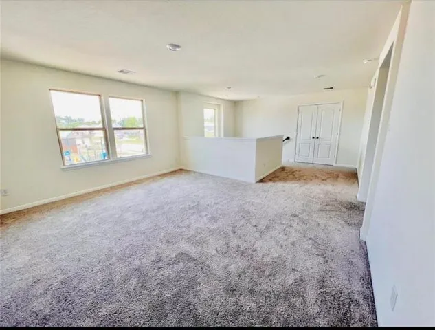 an empty room with windows and closet