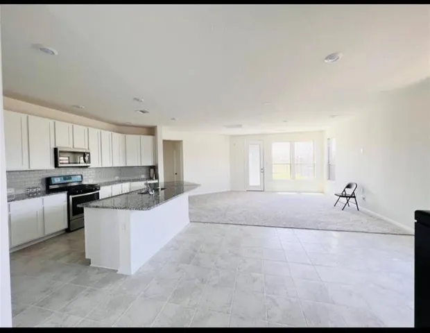 a large white kitchen with stainless steel appliances