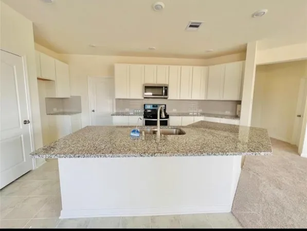 a kitchen with stainless steel appliances granite countertop a sink and a granite counter tops