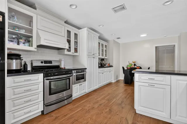 a kitchen with stainless steel appliances white cabinets and white appliances