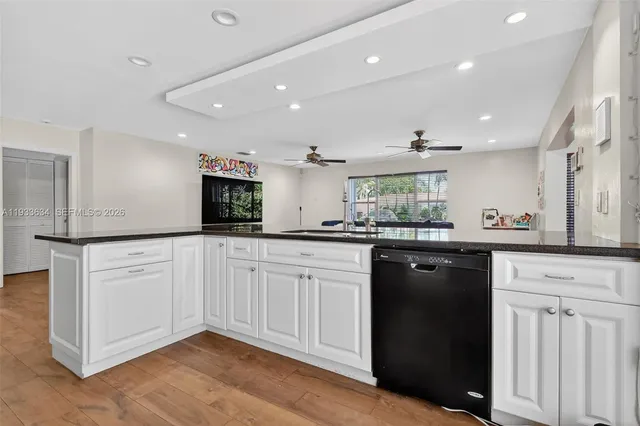 a kitchen with granite countertop white cabinets and white appliances
