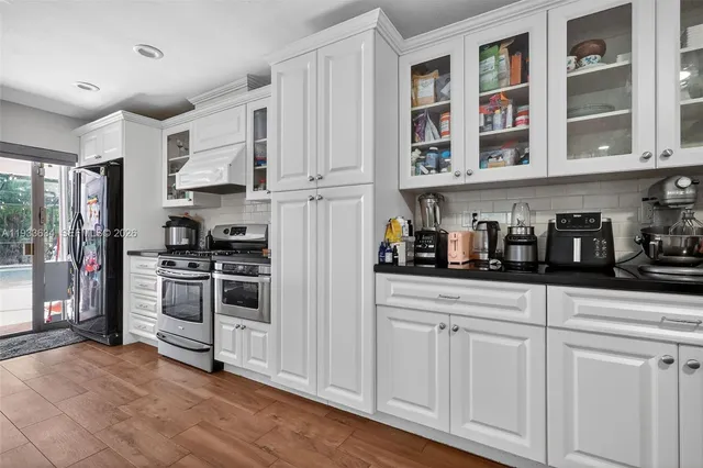 a kitchen with stainless steel appliances granite countertop a refrigerator and cabinets