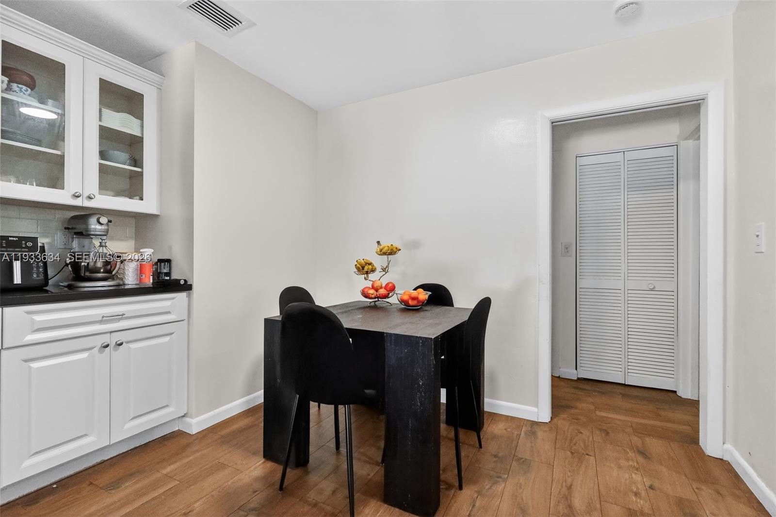 11890 Southwest 72nd Place Pinecrest, FL 33156 - Photo 16 of 39 a dining room with furniture and wooden floor