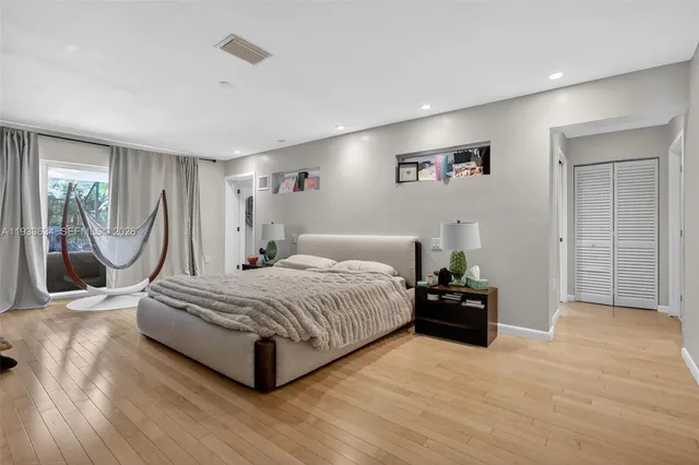 a spacious bedroom with a bed and a chandelier