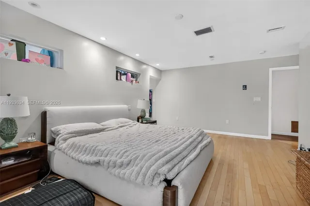 a bedroom with a bed and wooden floor